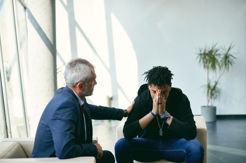 Depressed teenager having a meeting with his therapist