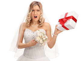 Displeased bride holding a wedding gift