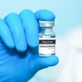 Doctor wearing blue gloves holding a vial of Lenacapavir vaccine