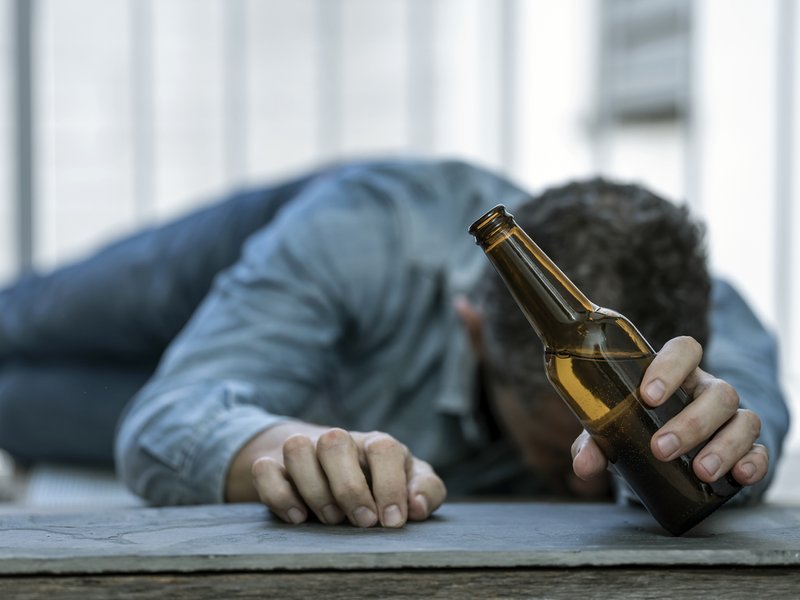 Drunk man with alcohol in hand iStock