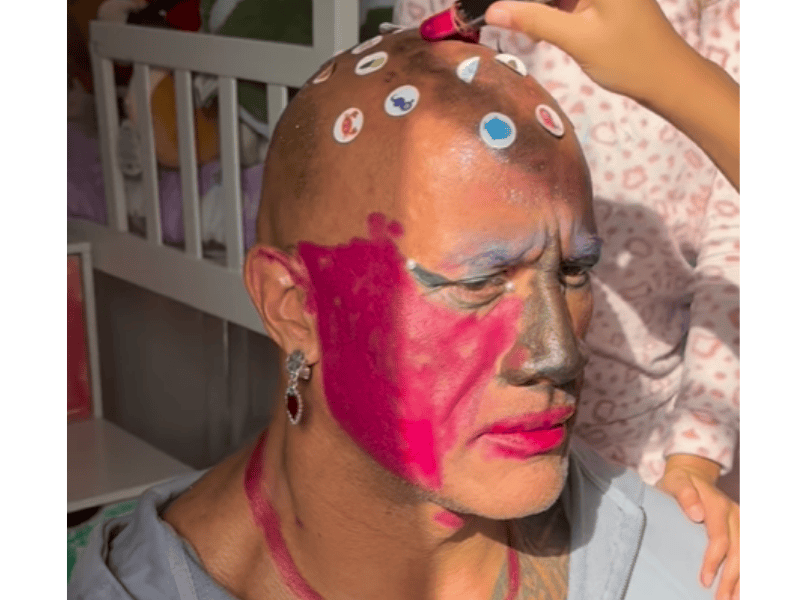 Dwayne Johnson has makeup all over his face while playing with daughters