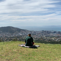 Ed Sheeran sitting on a grassy hill in Cape Town
