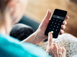 Senior woman dials emergency number on phone