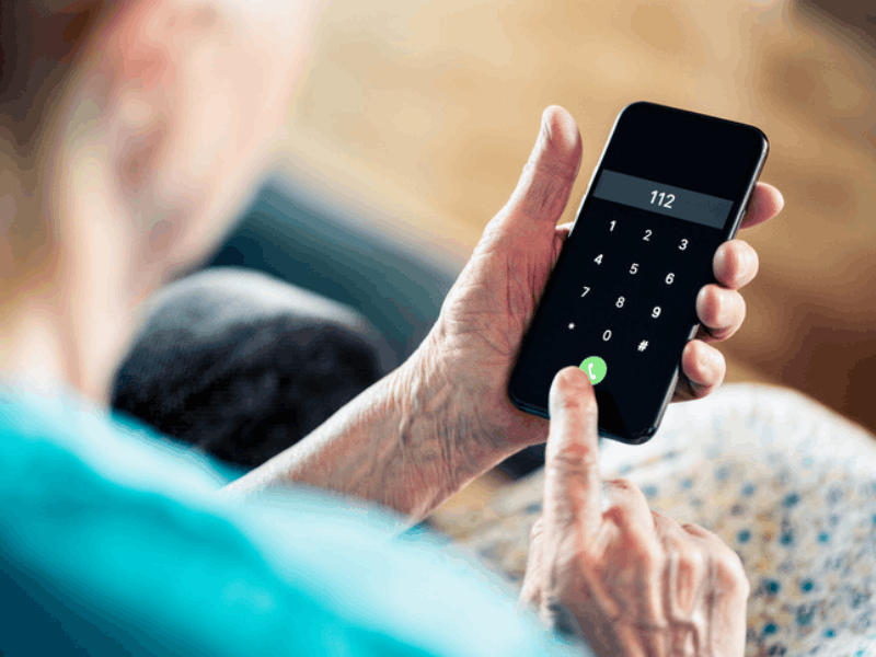 Senior woman dials emergency number on phone