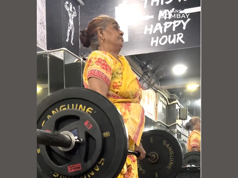Elderly woman lifting weights at the gym