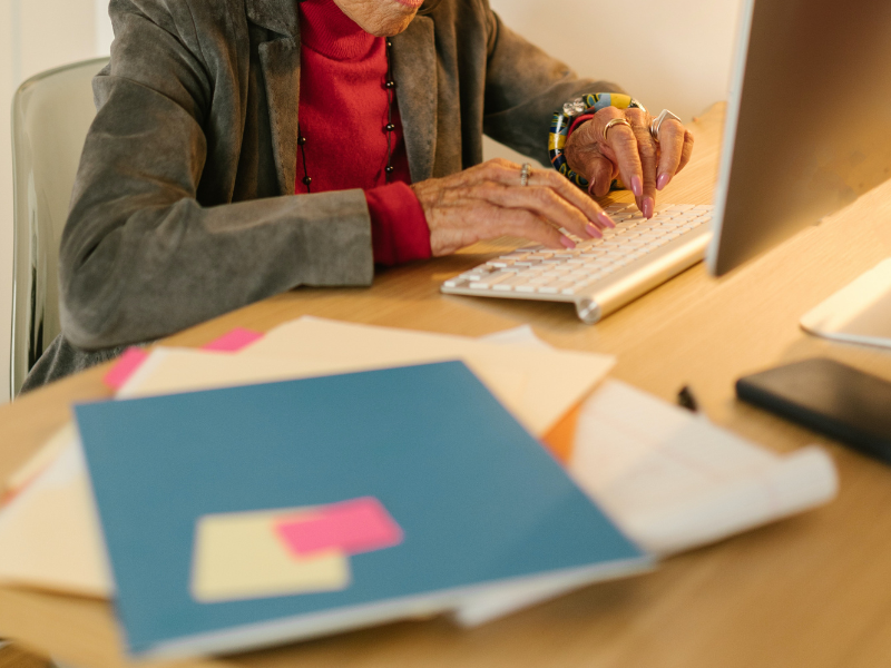 Elderly woman typing on computer