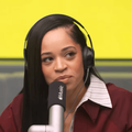 Ella Mai speaks into a mic with an Apple Music logo
