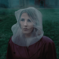 Ellie Goulding wearing a deep red coat and sheer veil over her head