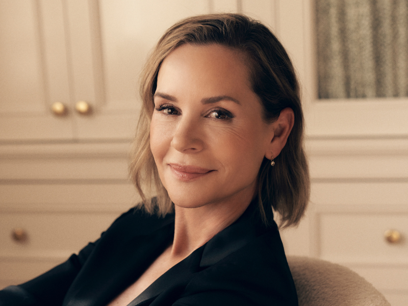 Embeth Davidtz seated on a lounge chair in a well lit lounge area