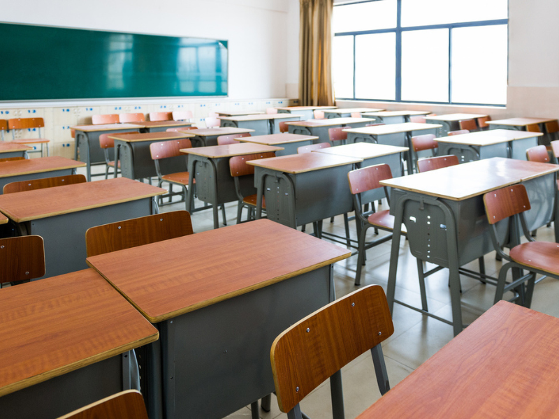 Empty classroom with desks, chairs and chalkboard