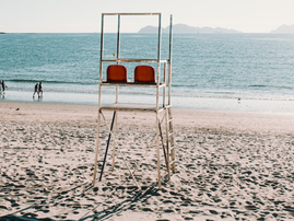 Empty lifeguard chair on sandy beach