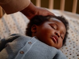 Face of Black Baby Girl Sleeping in Crib