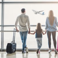 Family in airport watching flight about to take off