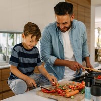 Father and son preparing food in kitchen