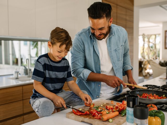 Father and son preparing food in kitchen