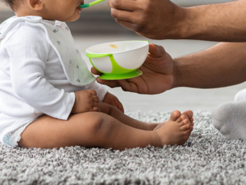 Father feeding his baby cereal