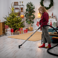 Festive cleaning in the home with a young girl vacuuming