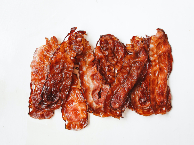 Fried strips of bacon on white surface