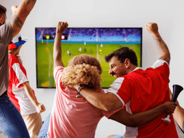 Friends cheering while watching football on TV