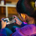 Girl playing live video game on mobile device