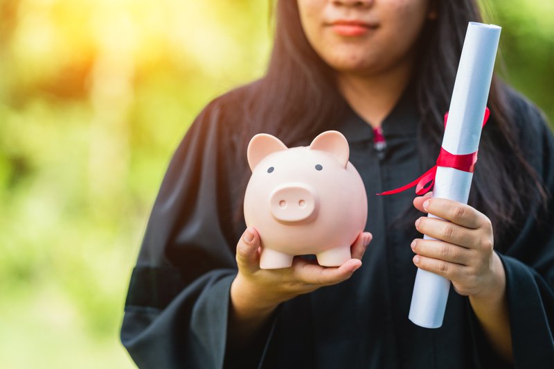 Graduates holding piggy banks