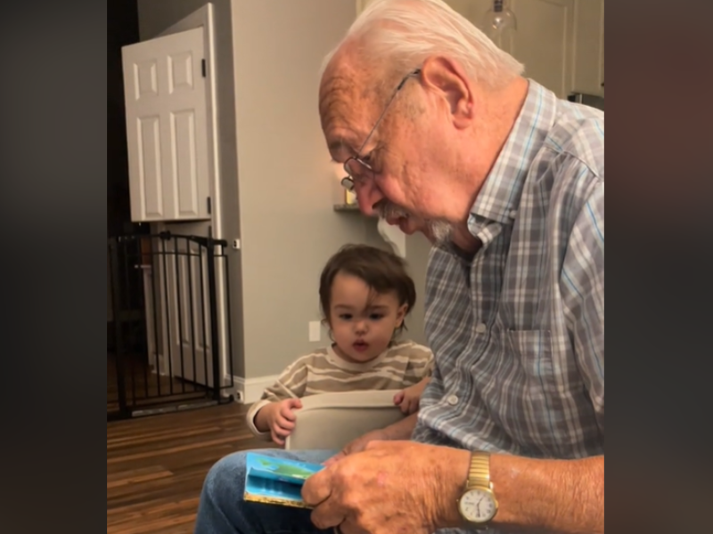 Grandfather reading to his granddaughter