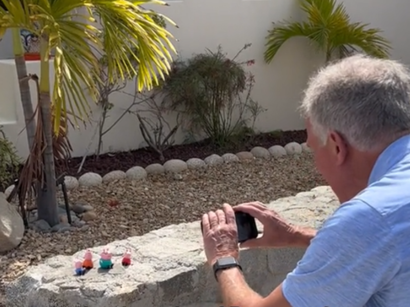 Grandfather taking pics of Peppa Pig toys
