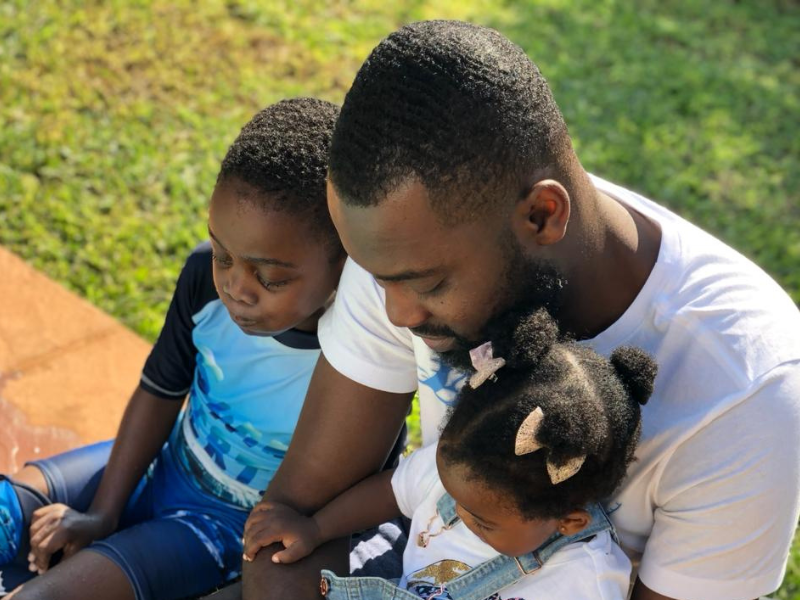 Greg Ofori sitting with his kids at the pool