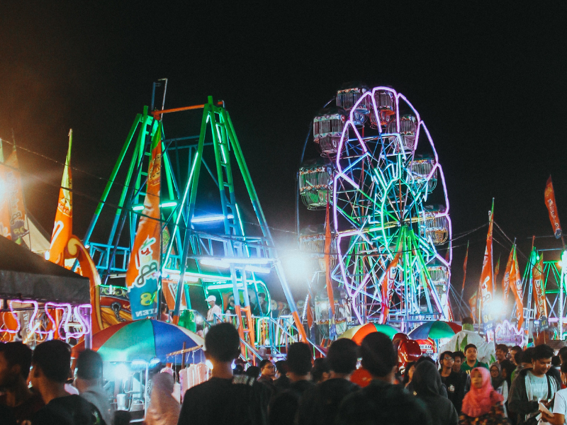 Group of people gather at a fun fair park