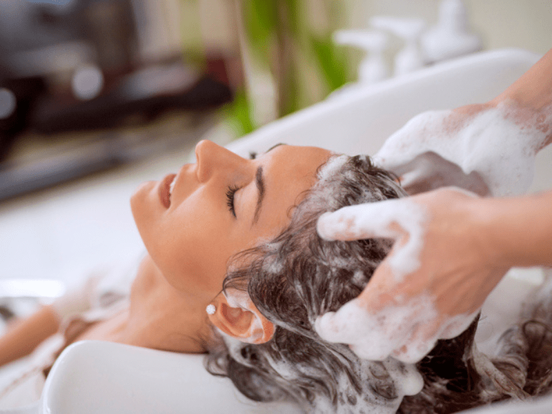 Hairdressed washing brunette woman's hair