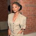 Halle Bailey poses next to a brick wall