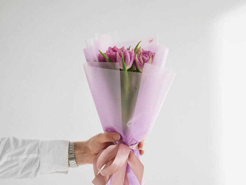 Hand holding bunch of pink flowers