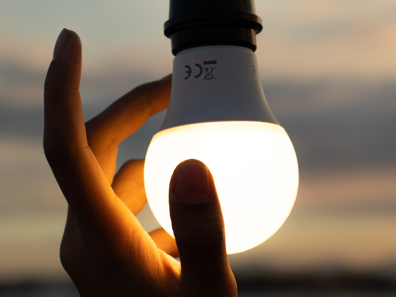 Hand touching a light bulb