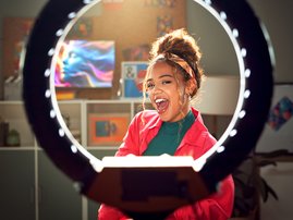 Happy woman with ring light for video recording
