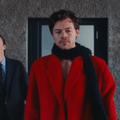 Harry Styles wearing a red coat