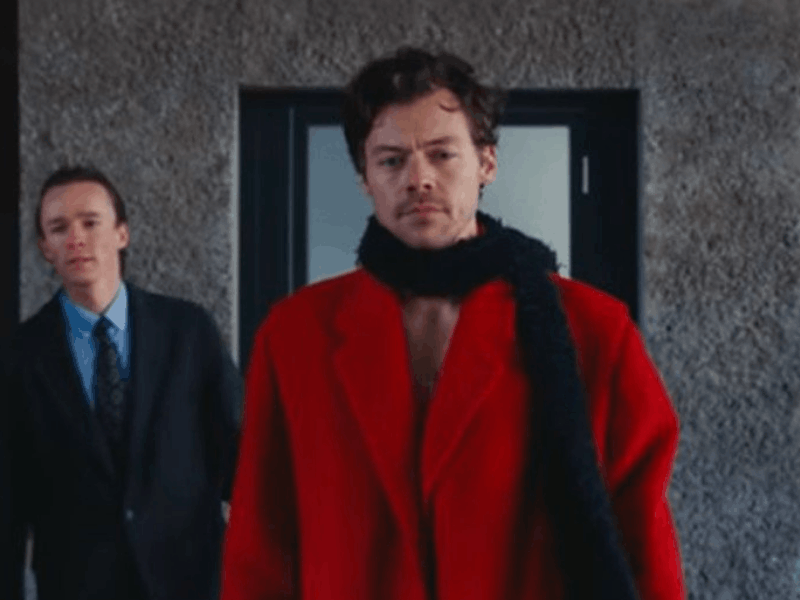 Harry Styles wearing a red coat