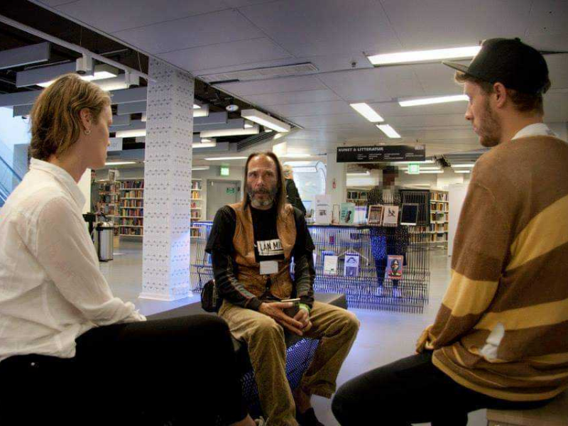 People seated listening to each other in a library