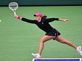 Iga Swiatek streches a forehand return Marta Kostyuk in their Indian Wells semi-final