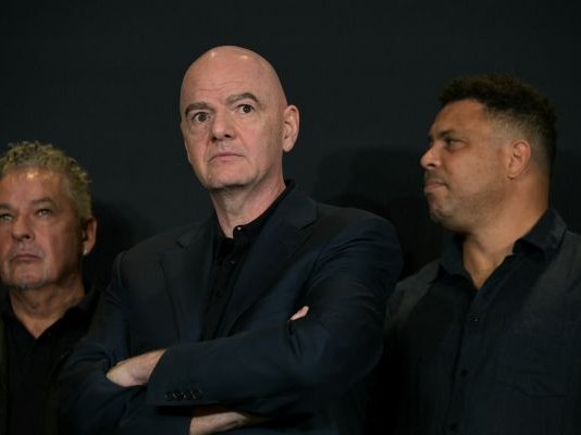 FIFA President Gianni Infantino listens next to former players Italian Roberto Baggio and Brazilian Ronaldo during a press conference