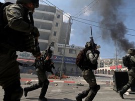 Israeli security forces deploy while clashing with Palestinians during the funeral of 19-year-old Labib Damidi, who was shot dead by settlers in the occupied West Bank town of Huwara on October 6, 2023