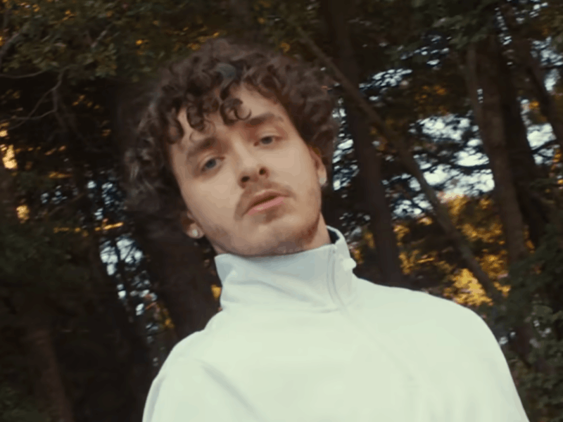 Jack Harlow poses outdoors in a white jacket