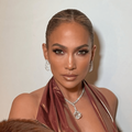 Jennifer Lopez's hair is styled in a slicked back bun with a middle part