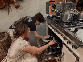 Jennifer Lopez crouched in front of am open oven