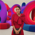 Jo-Ann Strauss poses next to a colourful piece of art