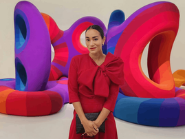 Jo-Ann Strauss poses next to a colourful piece of art