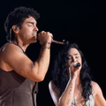 Joe Jonas and Demi Lovato singing together on stage
