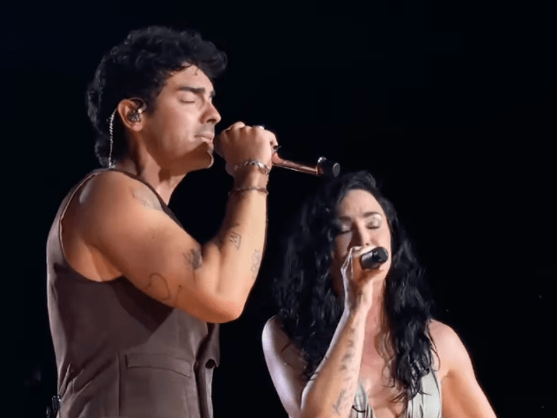 Joe Jonas and Demi Lovato singing together on stage