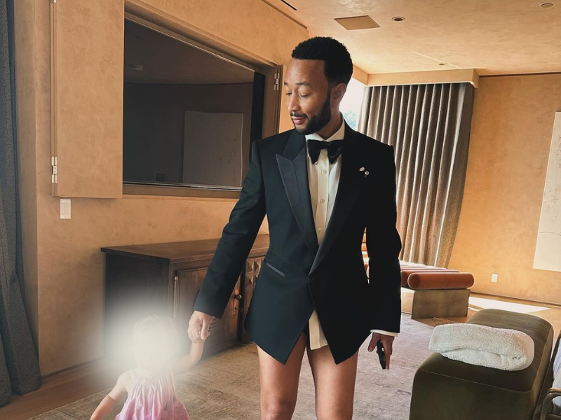 A pantsless John Legend holding his daughter's hand
