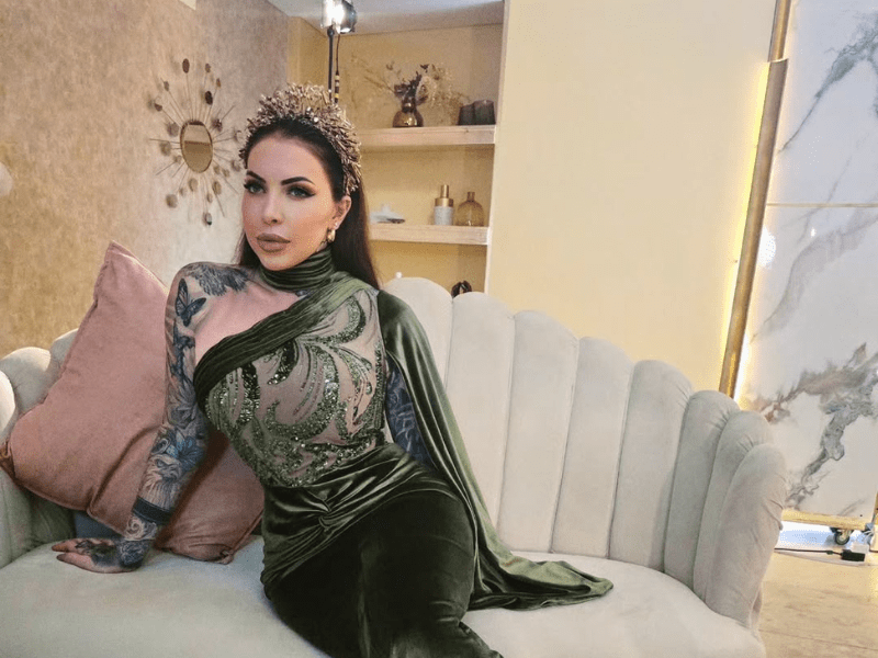 JoJo Robinson sitting on a plush sofa with scalloped edges