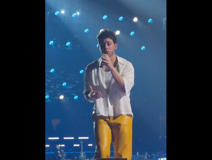 Singer Nick Jonas can be seen falling through a hole in a stage floor at a concert in Boston.